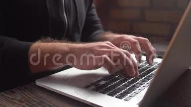 在阁楼咖啡厅用笔记本电脑键盘打字的人。近景：在笔记本电脑键盘上写字的人的手。